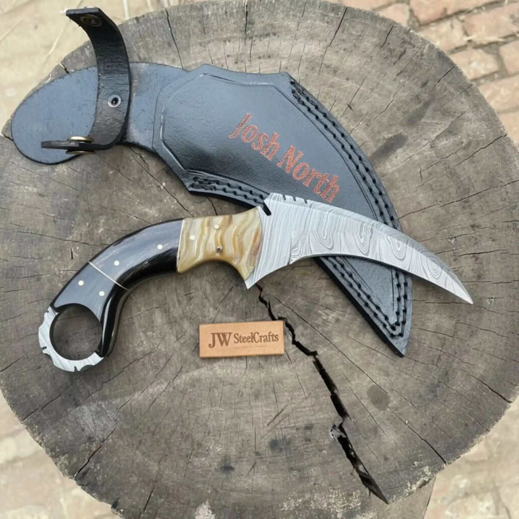 Handmade damascus steel knife with premium handle on dark surface