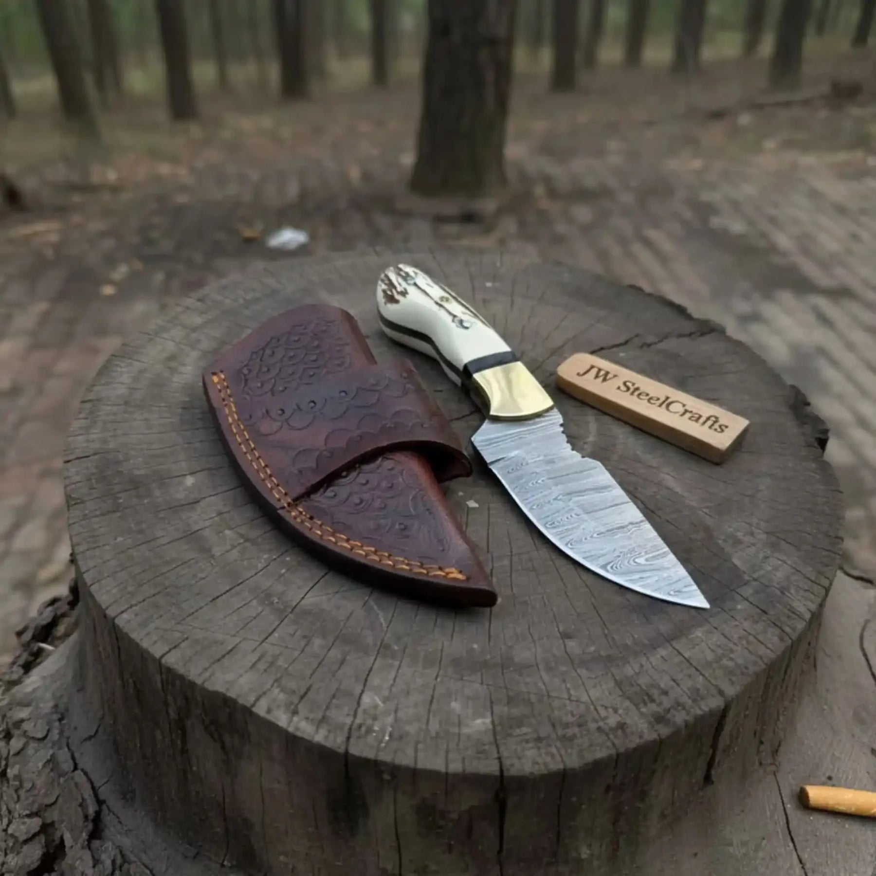 Handmade damascus steel knife with premium handle on dark surface