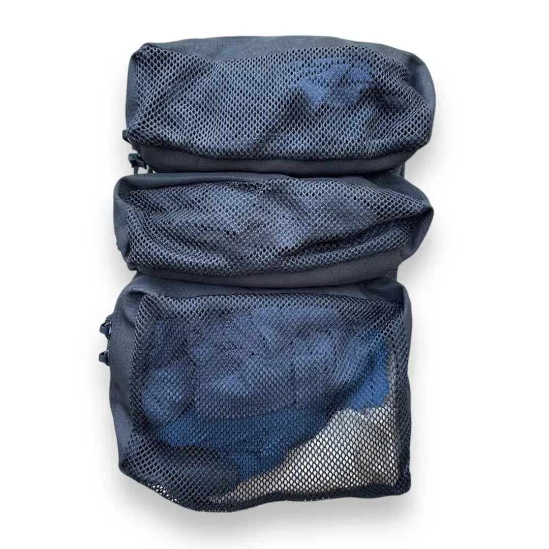 Dark blue backpack with three mesh zippered compartments, showing contents inside.