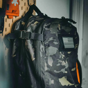 Camouflage backpack with American flag patch attached to loop fabric.