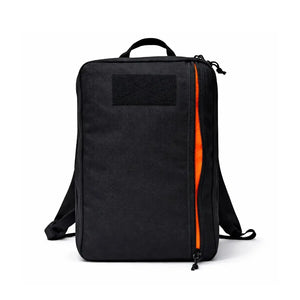 Black backpack with an orange zipper opening and a patch on the front.