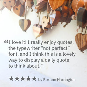 Close-up of wooden hearts, quote cards, and a five-star review by Roxann Harrington.