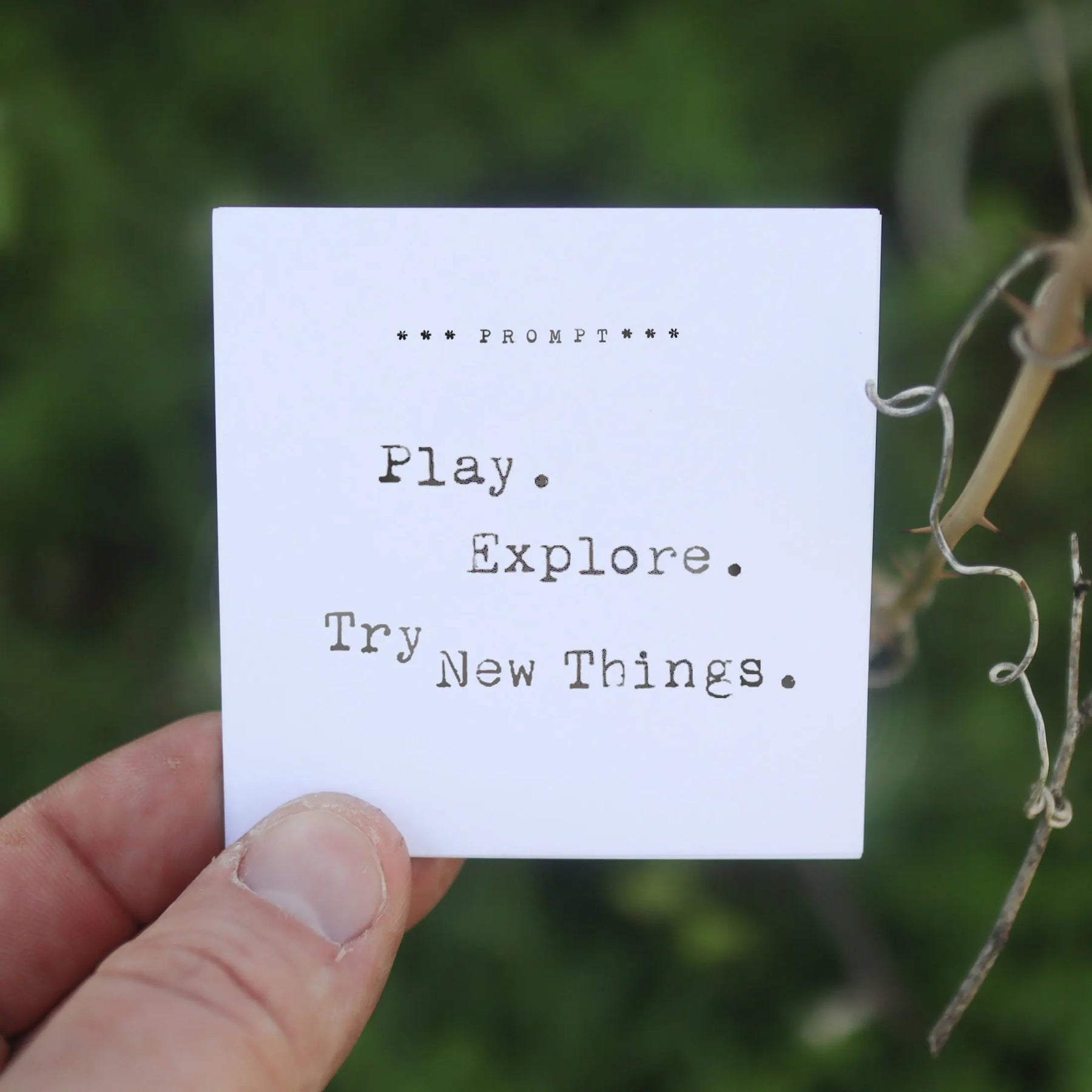 365 Imperfect Cards prompt "Play. Explore. Try New Things." held by a hand