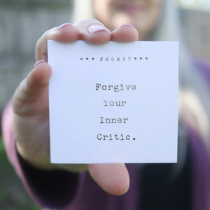 Card held by a hand with text 'Forgive Your Inner Critic.'