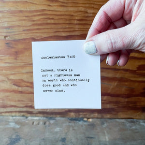 Card with Ecclesiastes 7:20 scripture and typewriter font held by a hand.