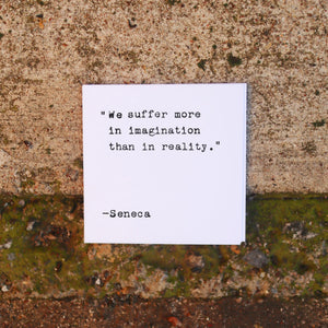 White card with quote from Seneca on textured concrete background.