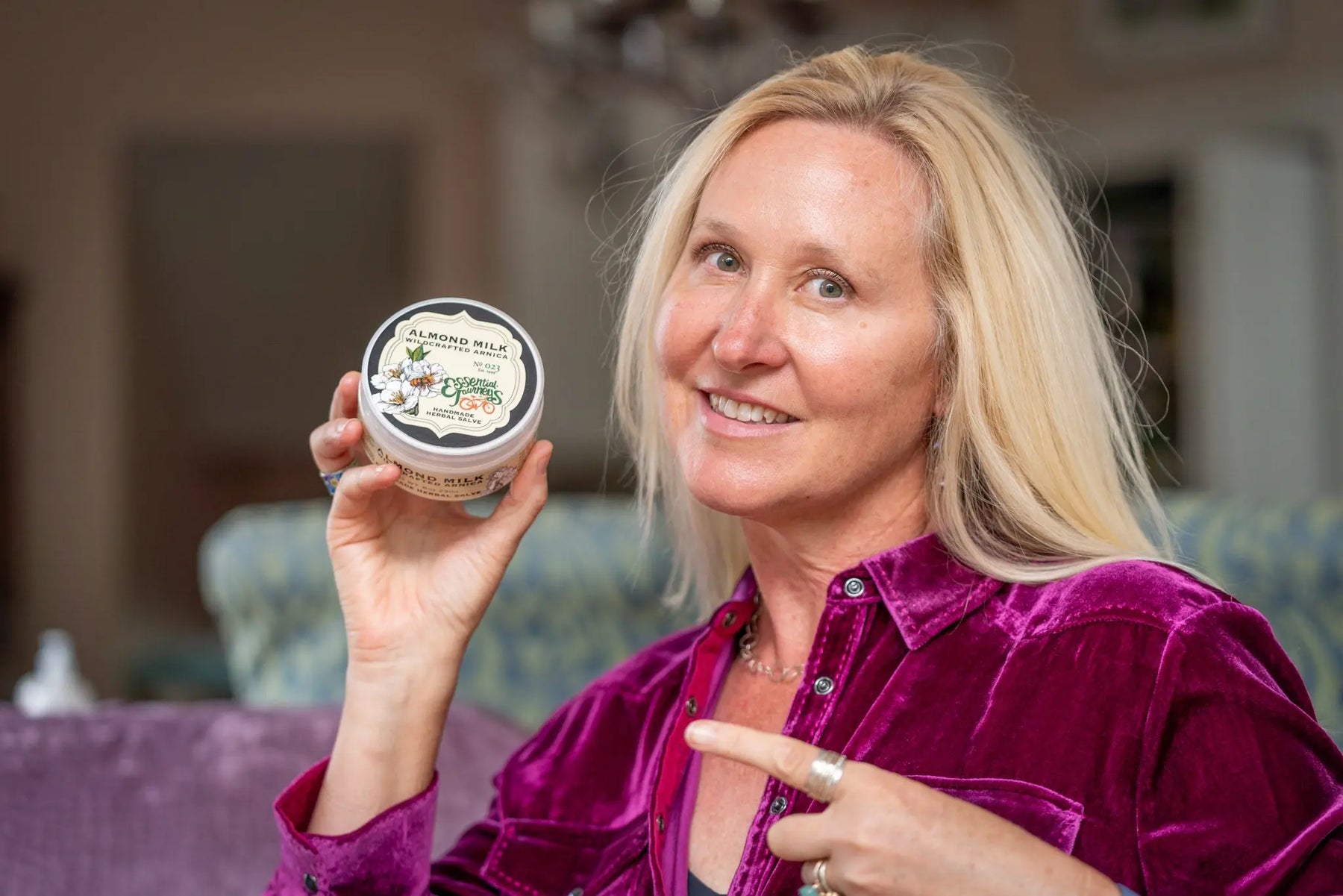 Woman holding Essential Journeys Almond Milk Arnica Salve.
