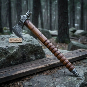 Damascus steel axe head with wood handle on rustic wood surface