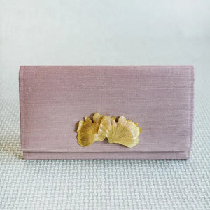 Lavender grasscloth clutch with gold ginkgo leaf embellishment and magnetic snap closure.