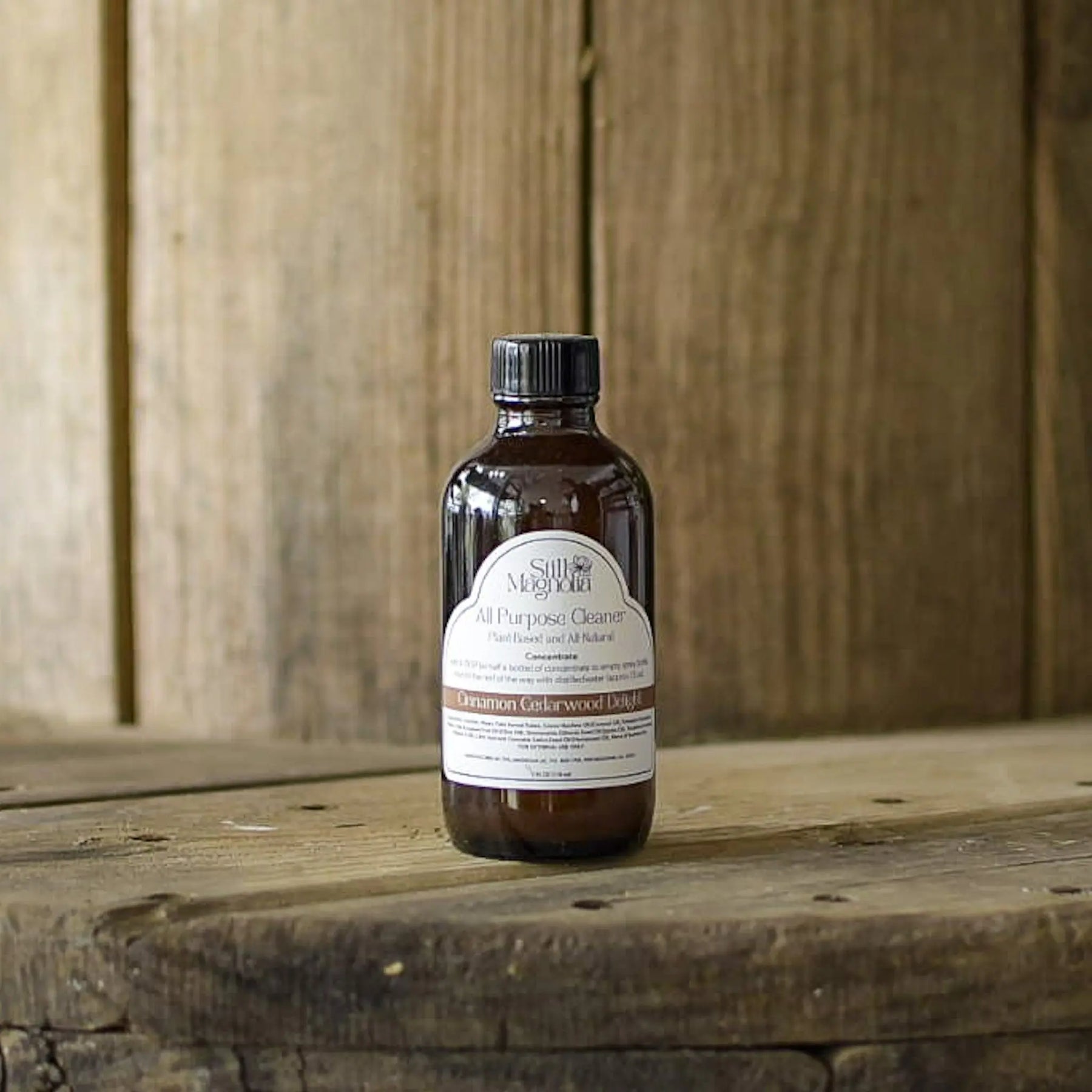 Brown glass bottle of Still Magnolia All Purpose Cleaner Concentrate in Cinnamon Cedarwood Delight scent.