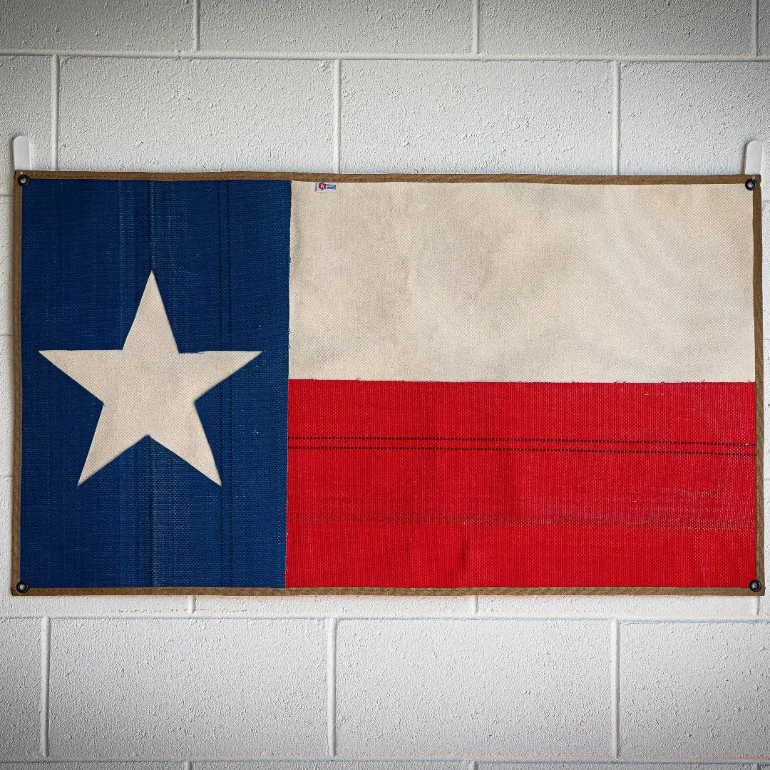 Texas flag made from red and white fire hose with blue stripe and white star.
