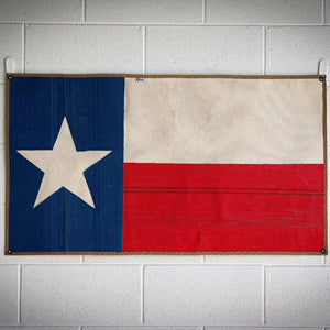Texas flag made from red and white fire hose with blue stripe and white star.