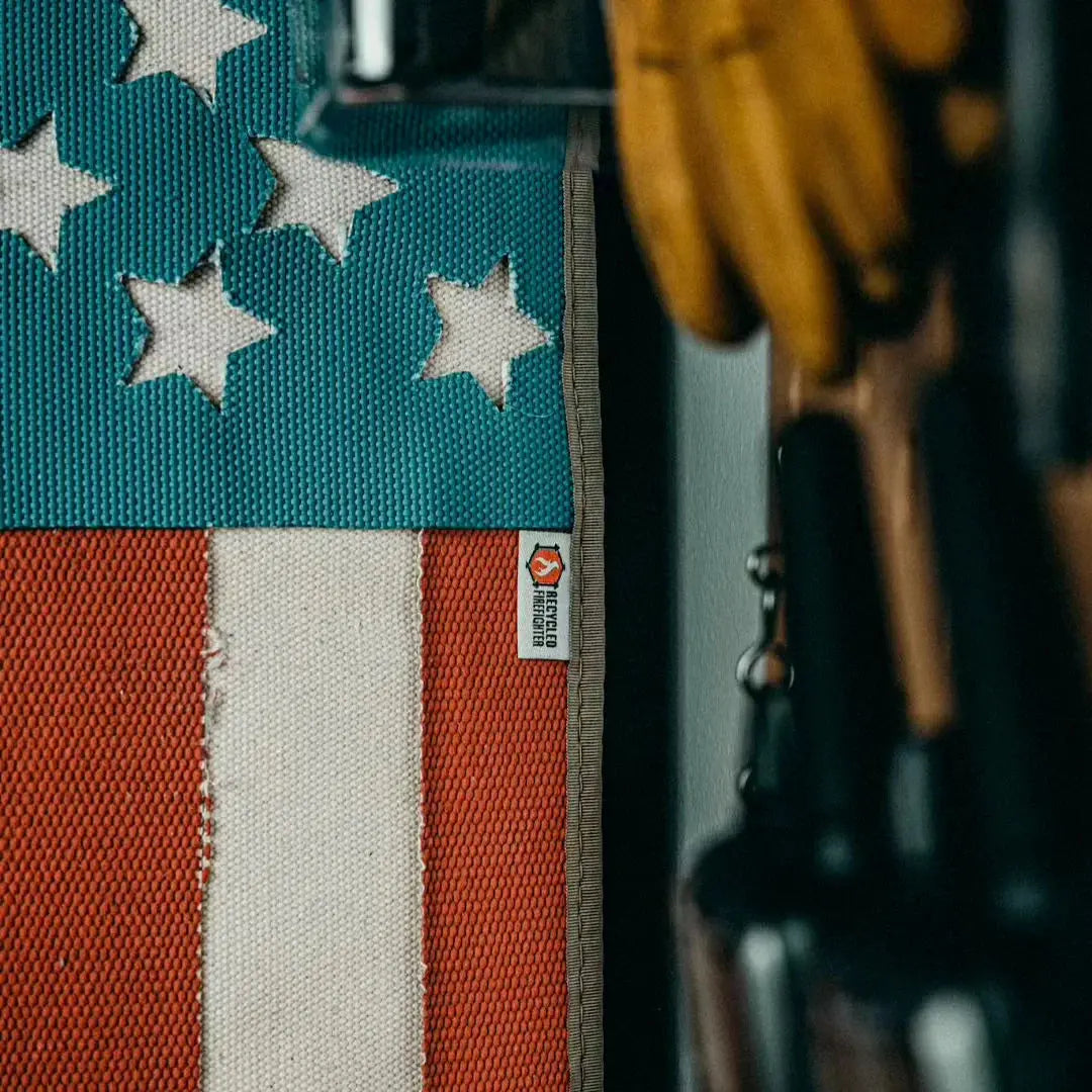 American flag made from red and white striped fire hose with blue fabric and white stars.