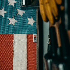 American flag made from red and white striped fire hose with blue fabric and white stars.