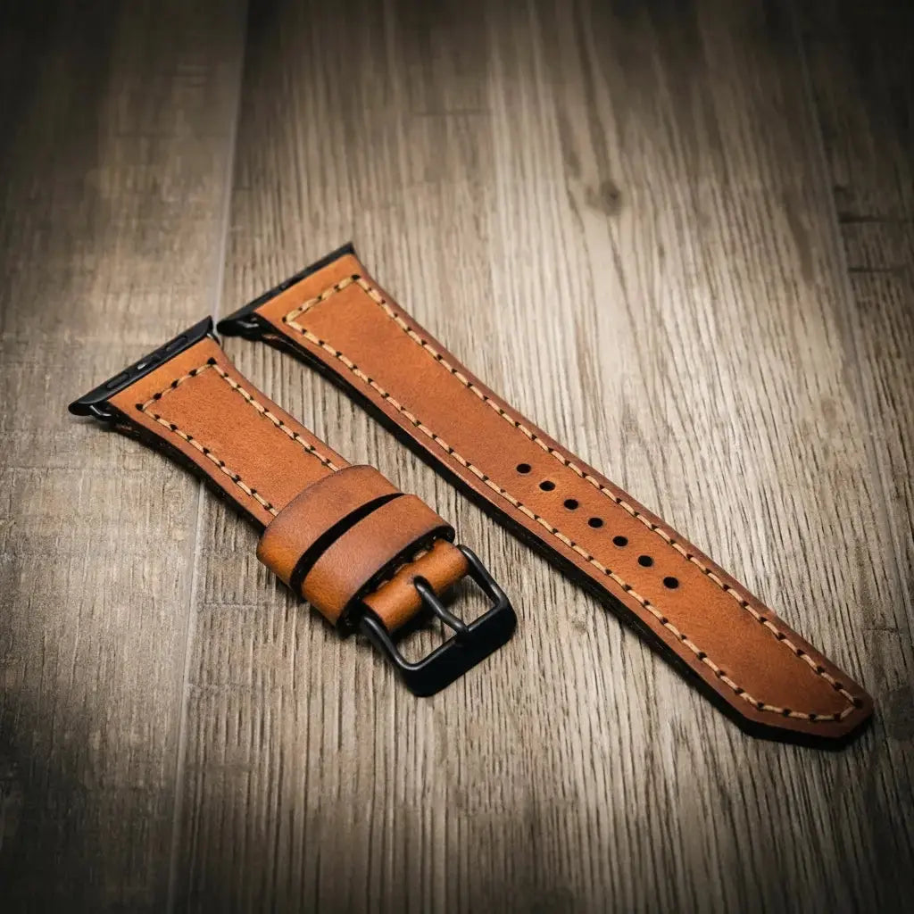 Brown full-grain leather Apple Watch band with black buckle.