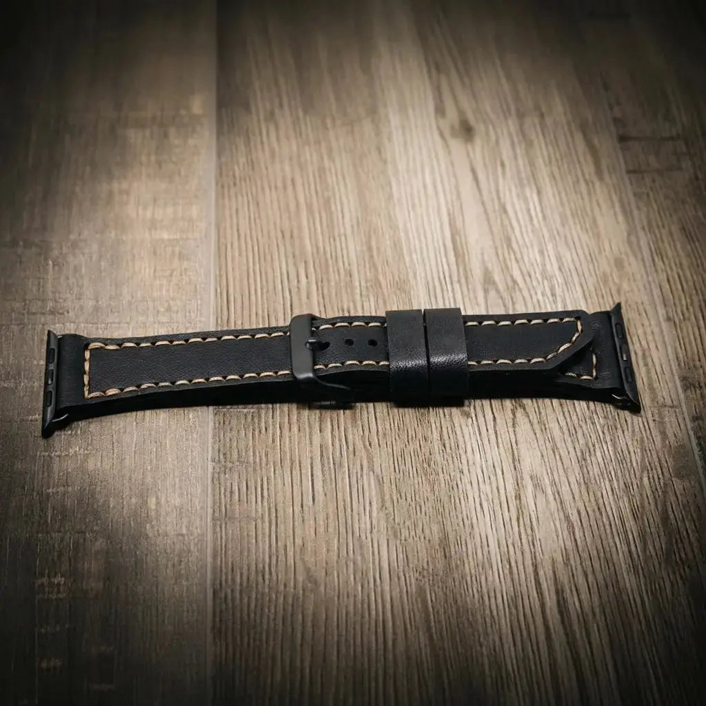Black leather Apple Watch band with tan stitching and a black buckle.