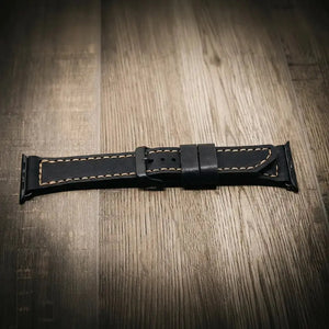 Black leather Apple Watch band with tan stitching and a black buckle.