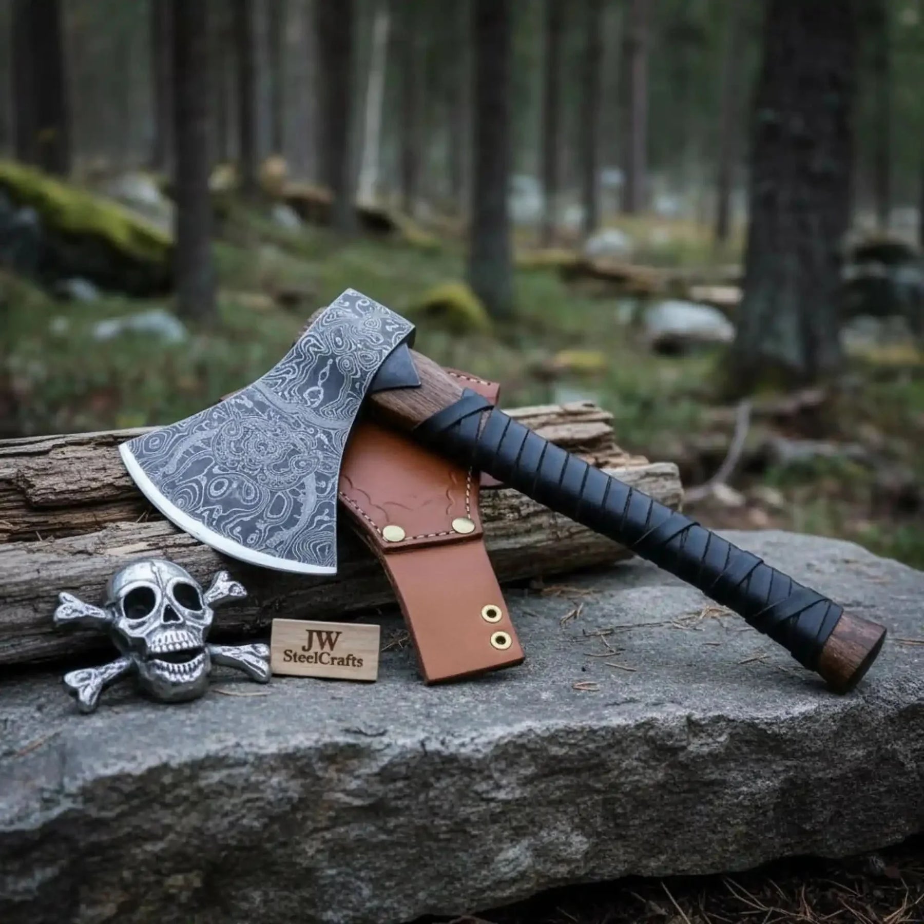 Damascus steel axe head with leather handle on rustic wood surface