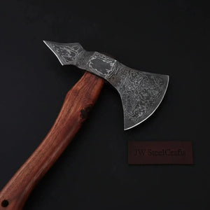 Damascus steel axe head with premium handle on rustic wood surface