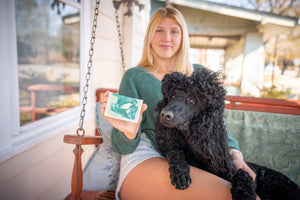 Balsam goats milk soap slice with green swirls, held by a person.