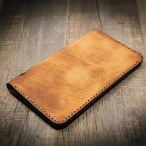 Brown leather long wallet with stitched edges and a badge slot.