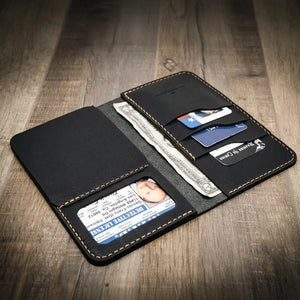 Black leather long wallet open showing ID, cards, and bills