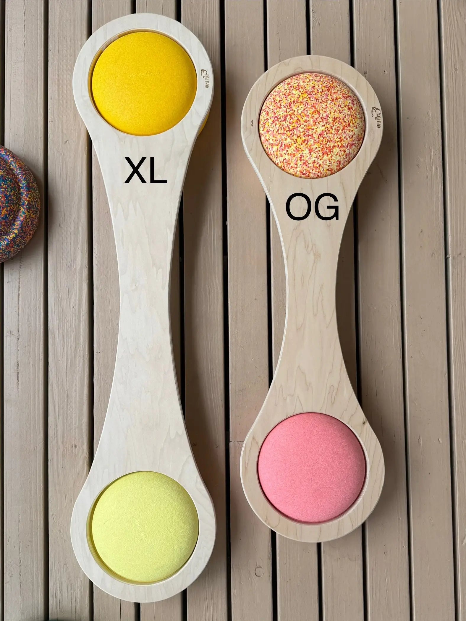 Wooden balance boards with circular openings, one labeled XL and the other OG.