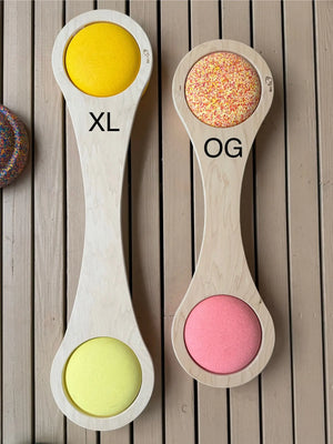 Wooden balance boards with circular openings, one labeled XL and the other OG.