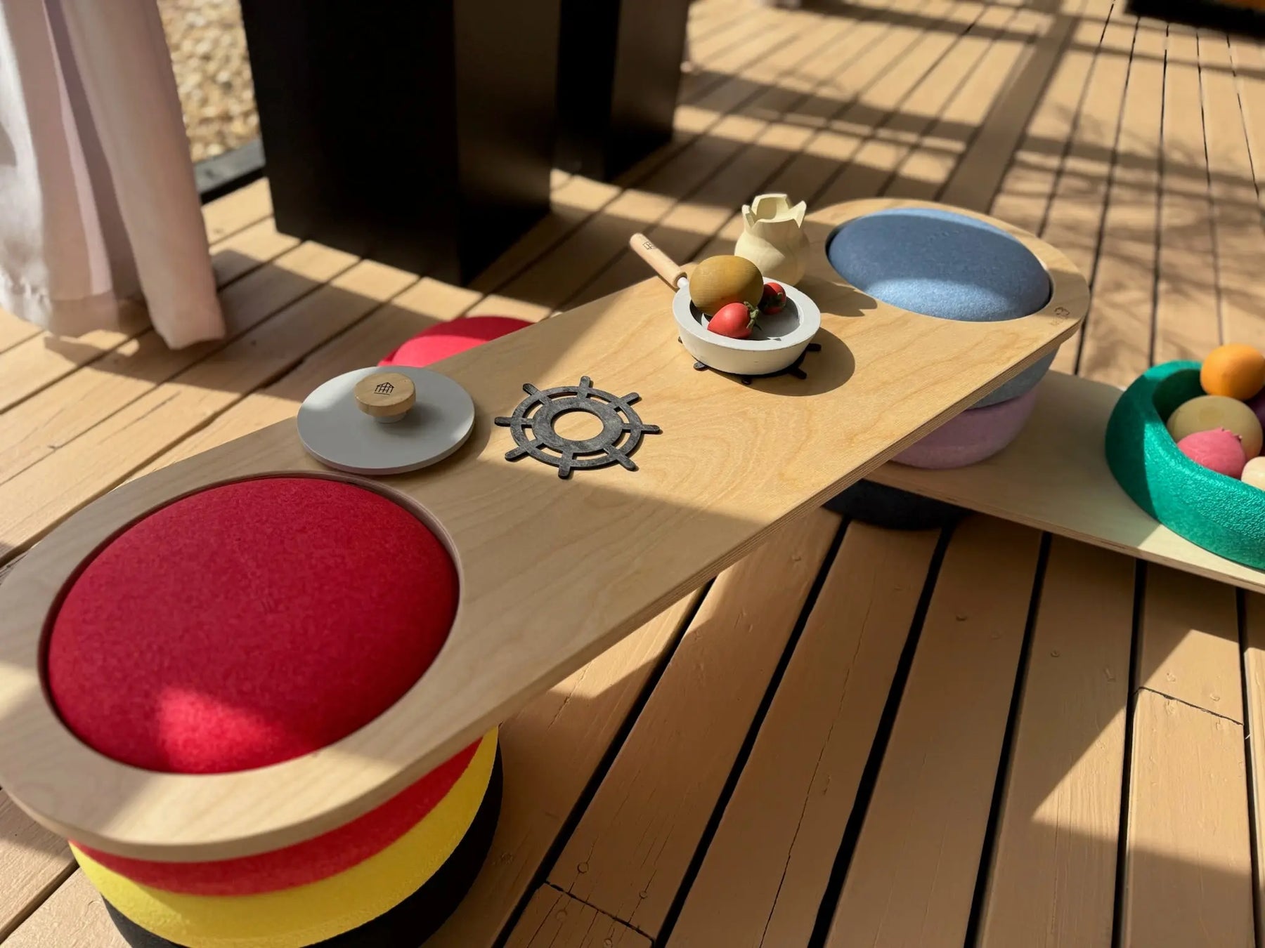 Wooden balance board with colorful play pieces for Stapelstein children's toys.