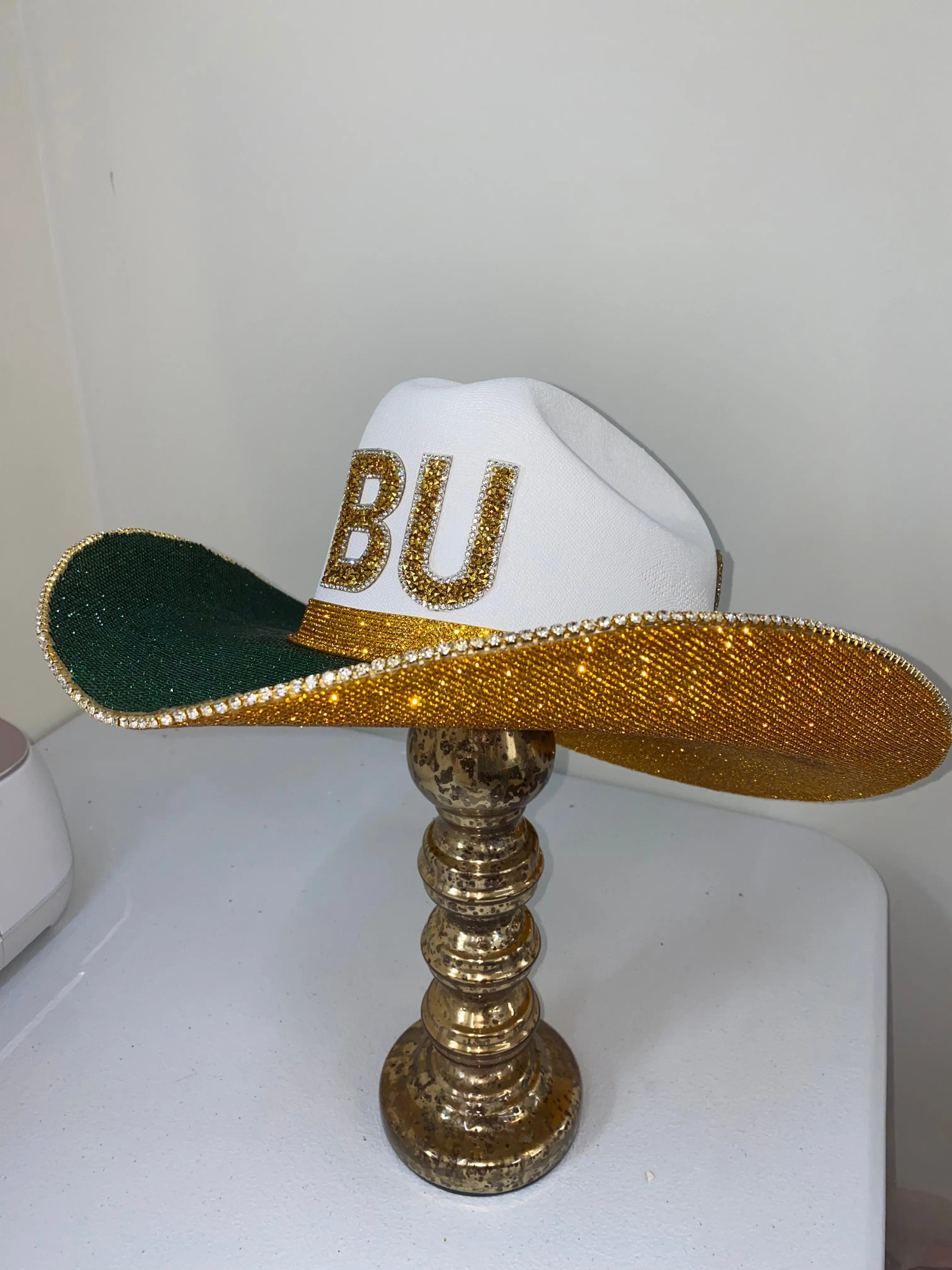White Baylor University cowboy hat with gold rhinestones and green brim.