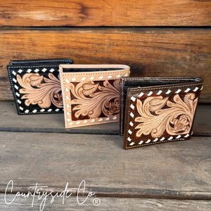 Three tooled leather men's bi-fold wallets with floral patterns and contrasting stitching.