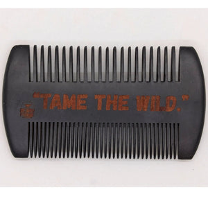 Black wooden comb with "TAME THE WILD." engraved on it.
