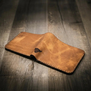 Brown leather bifold wallet with embossed bull logo, shown open.