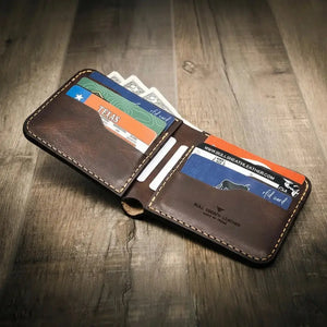 Brown leather bifold wallet with cards and cash visible.