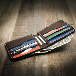 Big Bend Bifold Wallet made of dark brown leather, open with cards and cash inside.