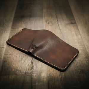 Brown leather bifold wallet with embossed bull logo.