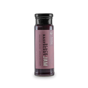 Glass jar of Black Raspberry Jam with Bourbon brand label and descriptive text.