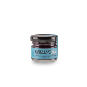 Small glass jar of blueberry cardamom jam with a blue label