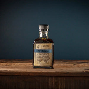 Bottle of Bluegrass Soy Sauce with a dark liquid on a wooden surface.