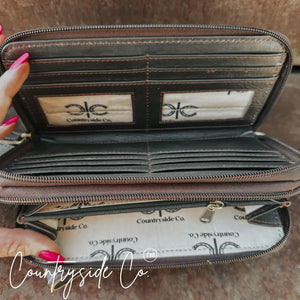 Brown leather wallet wristlet with multiple card slots and zipper closure.
