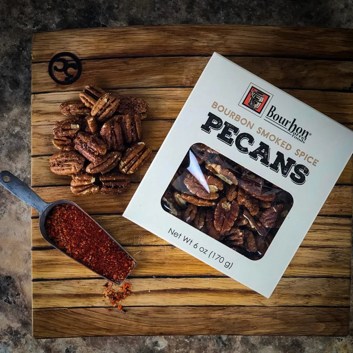 Bourbon Smoked Pecans on wooden board with seasoning scoop