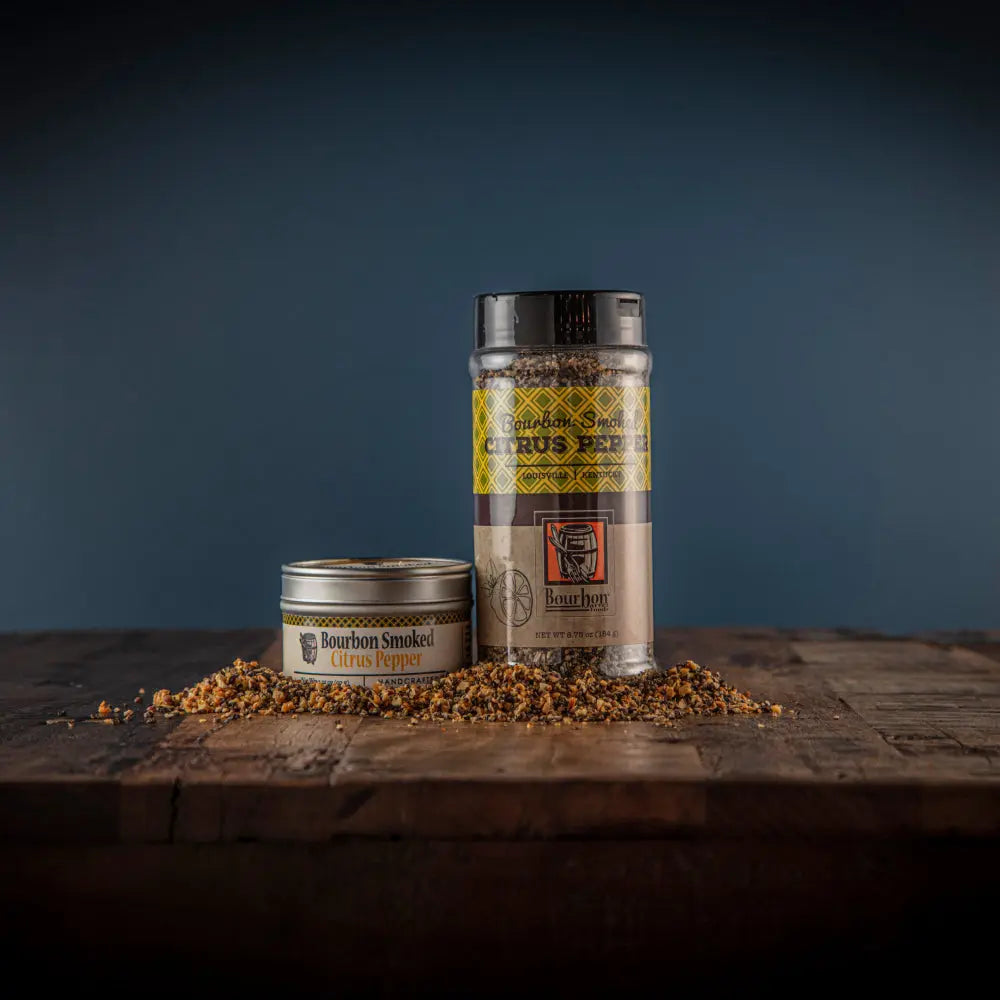 Bourbon Smoked Citrus Pepper spice blend in clear container with scattered spices