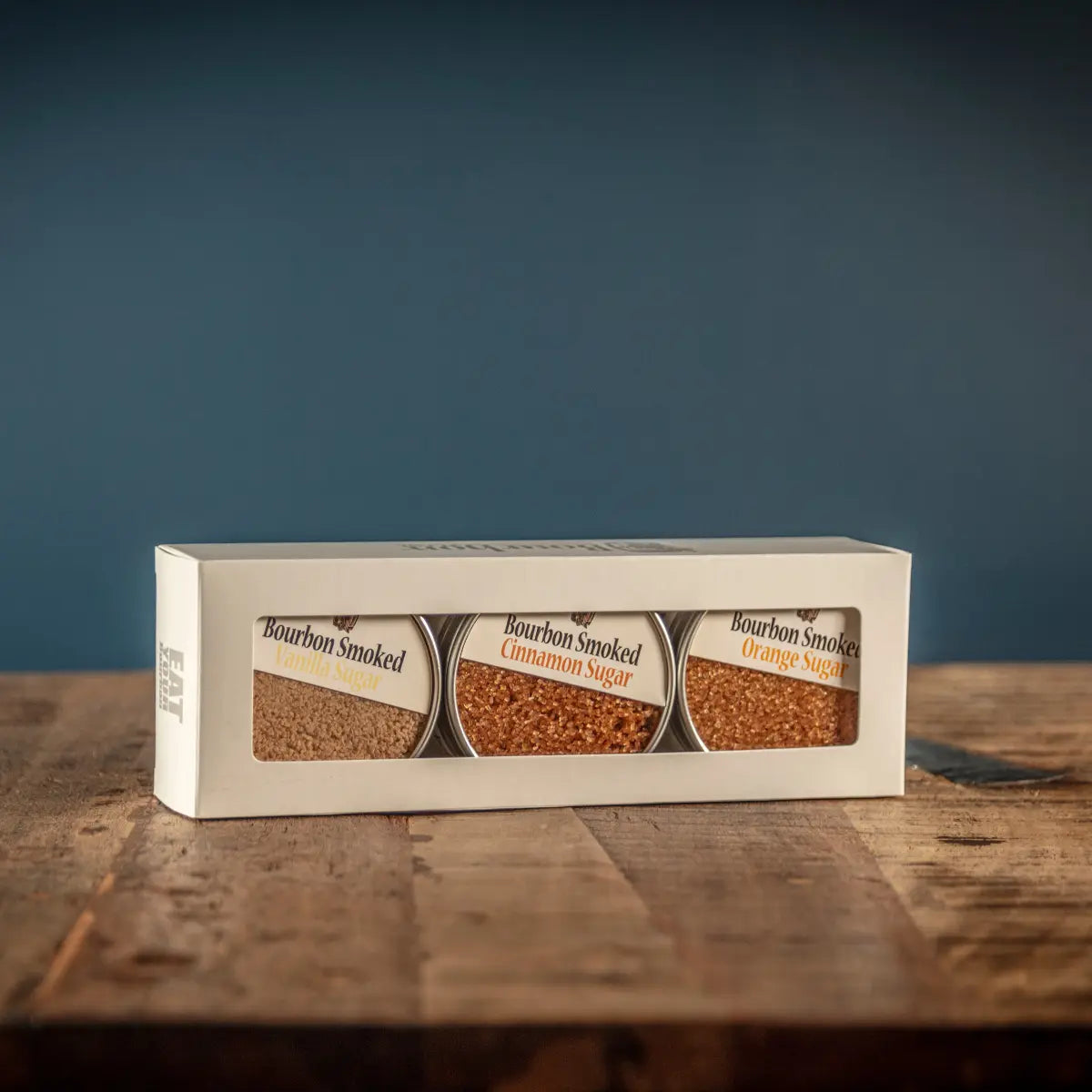 Bourbon Smoked Sugars Trio in glass jars: Orange, Vanilla, and Cinnamon.