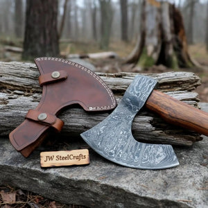 Damascus steel axe head with wood handle on rustic wood surface