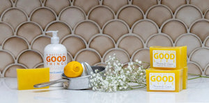 Yellow soap bars, hand soap bottle, and lemon on a kitchen counter with a tiled background.