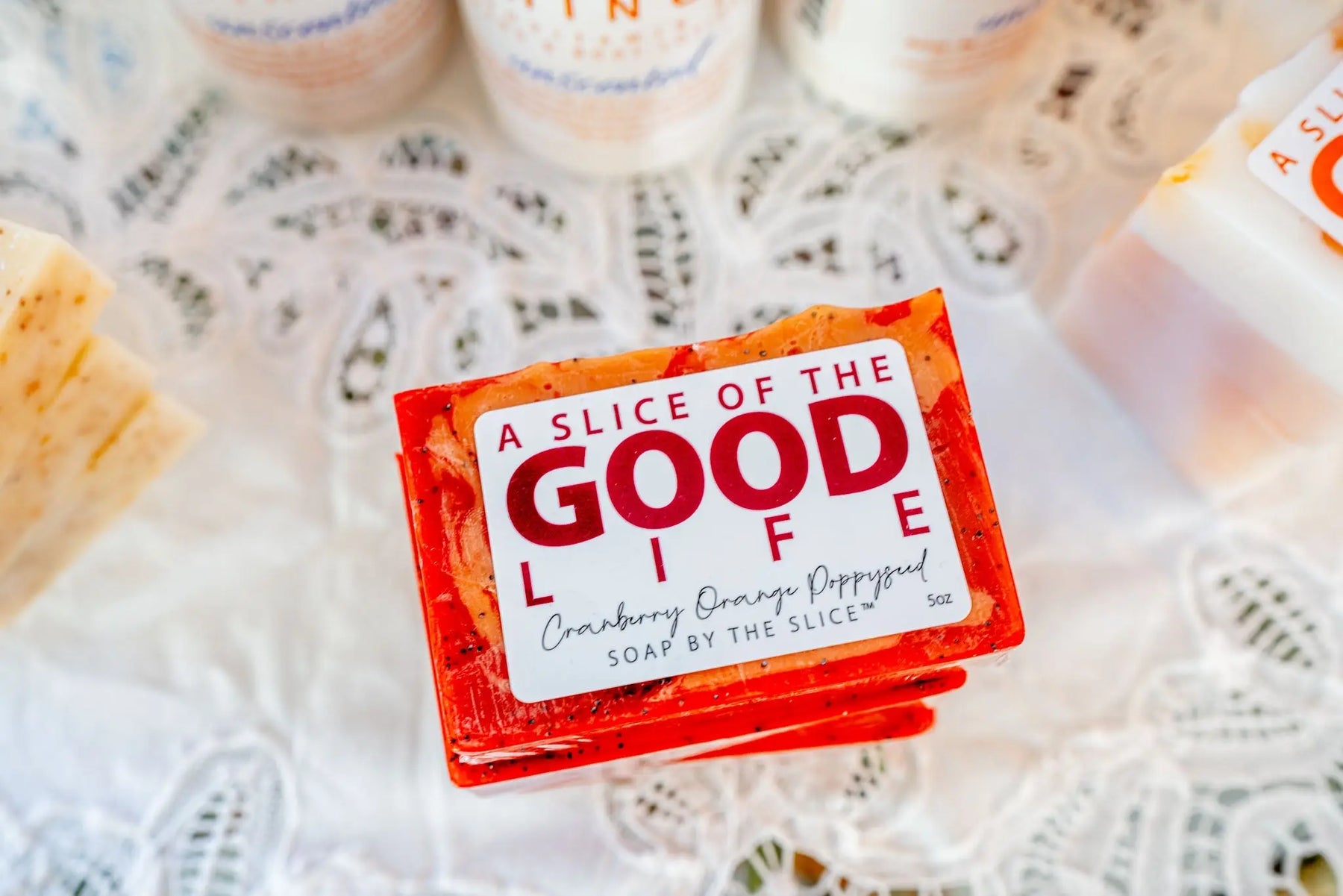Stack of orange cranberry orange poppy seed soap slices with "A Slice of the Good Life" label.