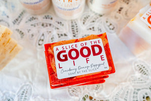 Stack of orange cranberry orange poppy seed soap slices with "A Slice of the Good Life" label.