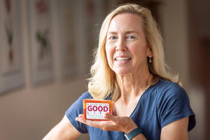 Woman holding a slice of Cranberry Orange Poppy Seed soap.