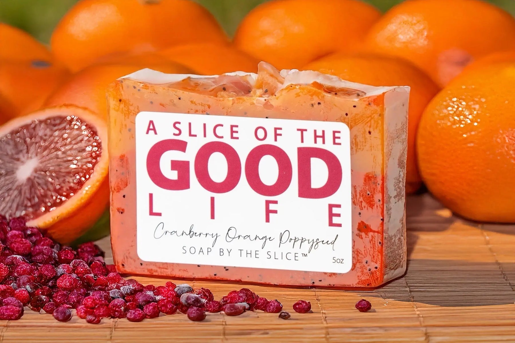 Cranberry Orange Poppy Seed soap slice with oranges and cranberries.