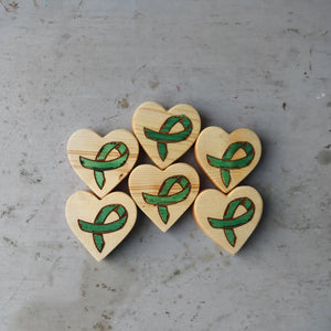 Wooden hearts with green awareness ribbons for cancer awareness